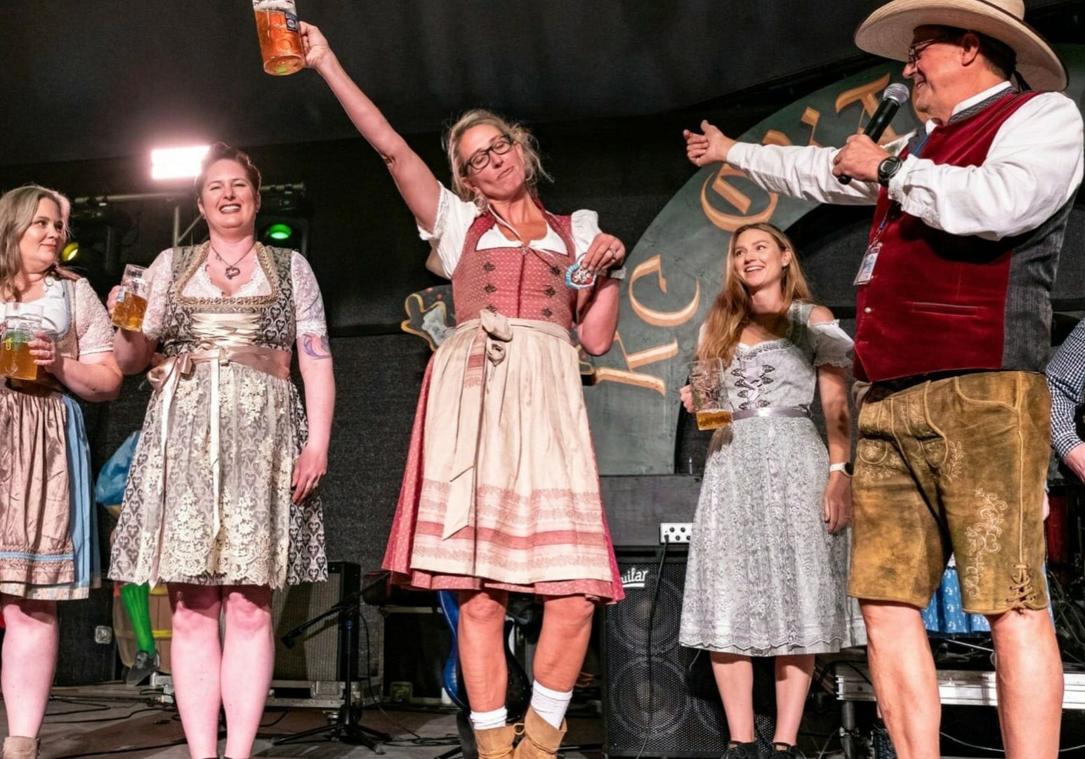 An on-stage Oktoberfest celebration with women holding steins.