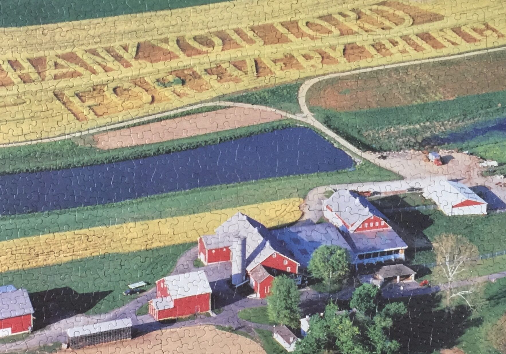 A completed puzzle of a farm landscape.