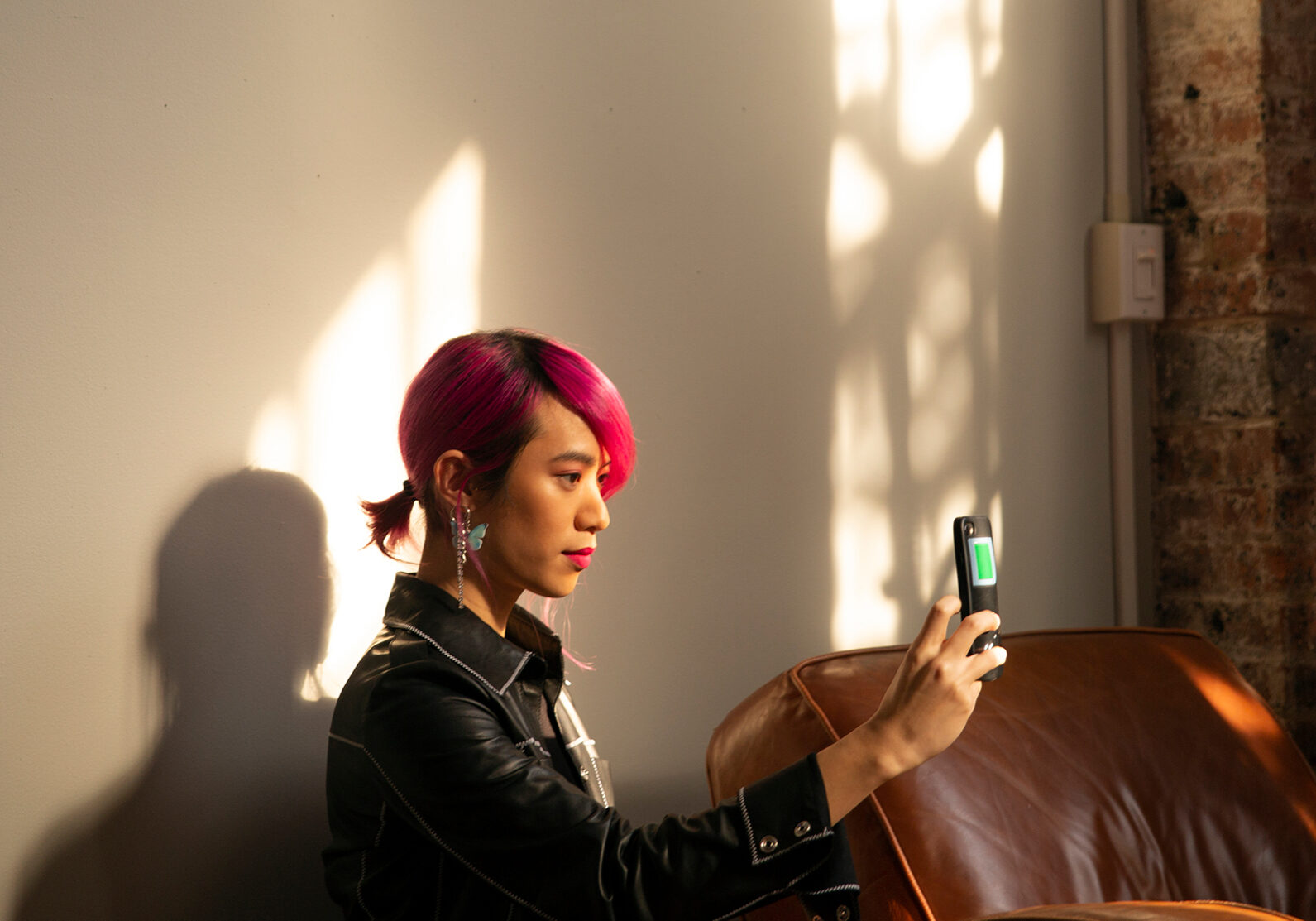 A non-binary femme using their phone