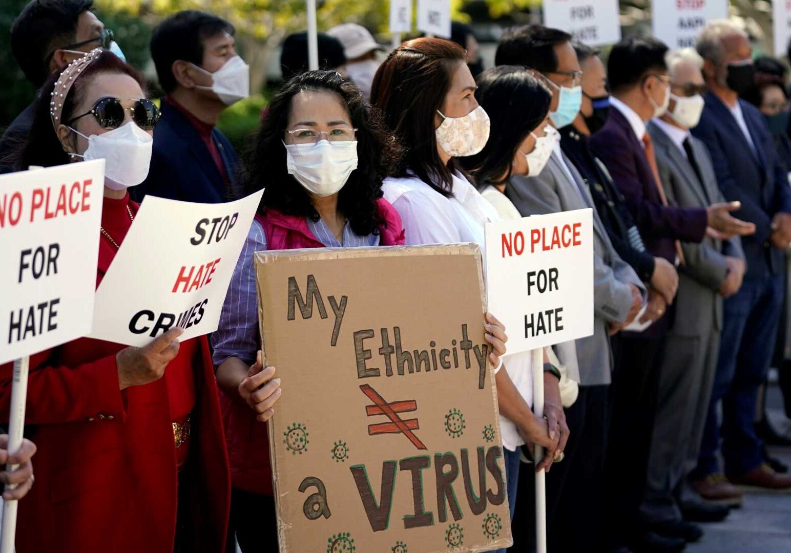 Demonstrators hold signs during a press conference calling to a halt on violence against Asian Americans
