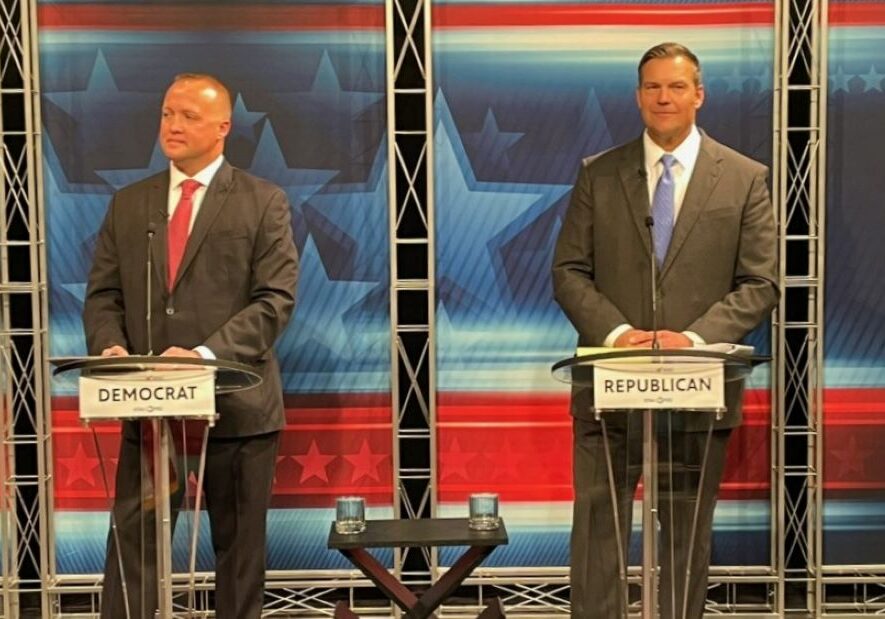 Democrat Chris Mann and Republican Kris Kobach on the debate stage.