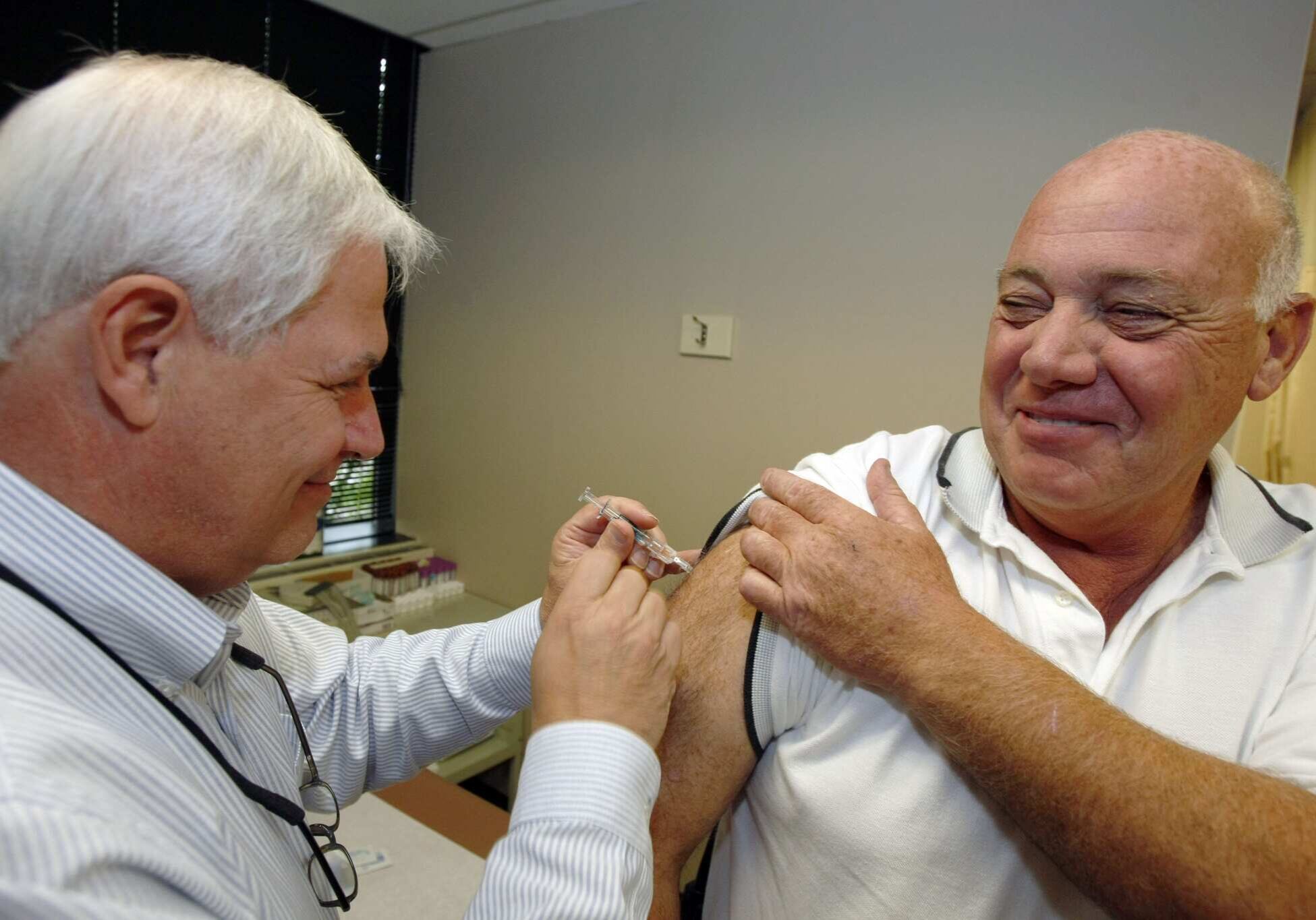 In this photo made on  Friday, Sept. 11, 2009, Safety and security specialist for the Bayer Corporation U.S. headquarters, Thomas Barclay, right, receives an inoculation for influenza from company physicians assistant Tim Grimes, in the Pittsburgh suburb Robinson, Pa. The initial doses of the new swine flu vaccine will only be given to young people, pregnant women and other high-risk groups. Businesses will have to wait until those folks have been immunized to get swine flu vaccine for their workforce. Unless they jump through lots of hoops that vary from state by state to get it, creating confusion for companies, like Bayer, with offices all over the country. (AP Photo/Keith Srakocic)