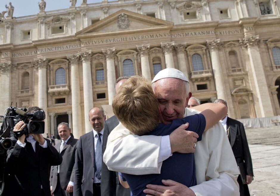 The pope gives a young boy a hug at the vatican