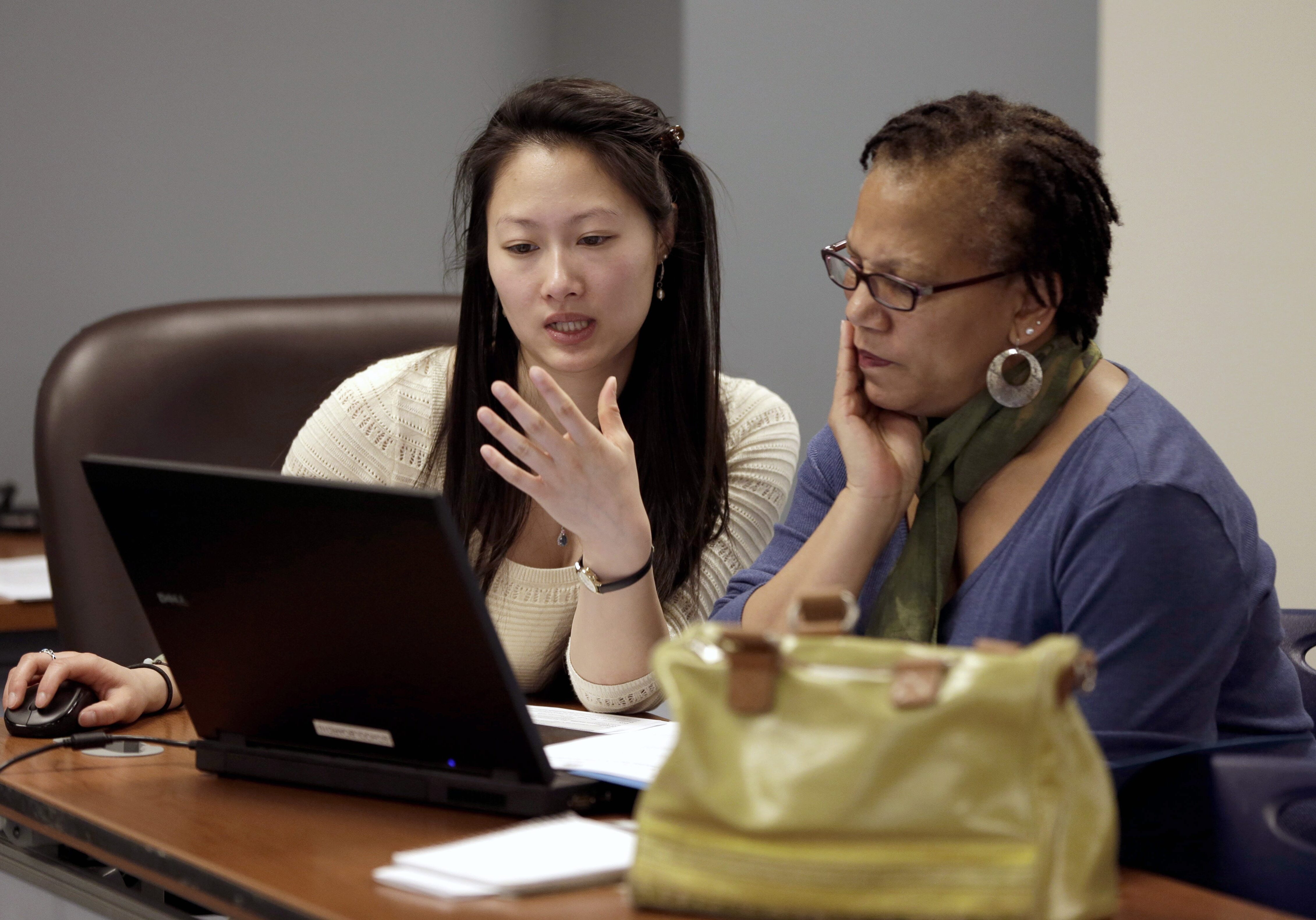 Counselor Jennifer Chen, left, assists Josette Jackson with questions while trying to enroll for health insurance Monday, March 31, 2014, in St. Louis. Missouri is one of 36 states where the online marketplace is being run by the federal government and also sought to limit the number of insurance counselors, known as navigators, who could help consumers understand a federal government website. (AP Photo/Jeff Roberson)