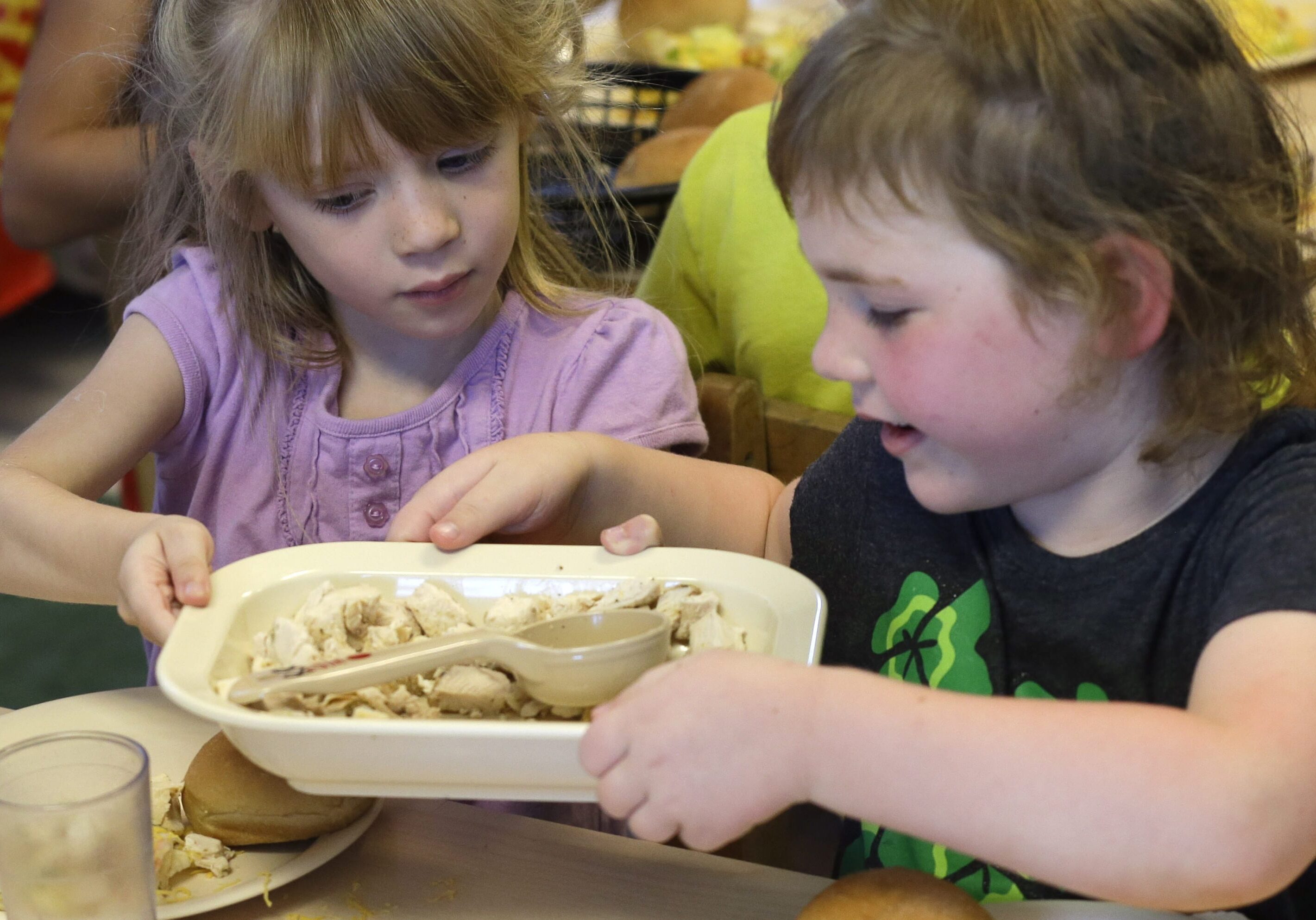 Children share a family-style meal during lunch at the Olathe Family YMCA in Olathe, Kan. An annual report on child well-being in Kansas shows steps forward and backward for the state. (Photo: Orlin Wagner | AP File)