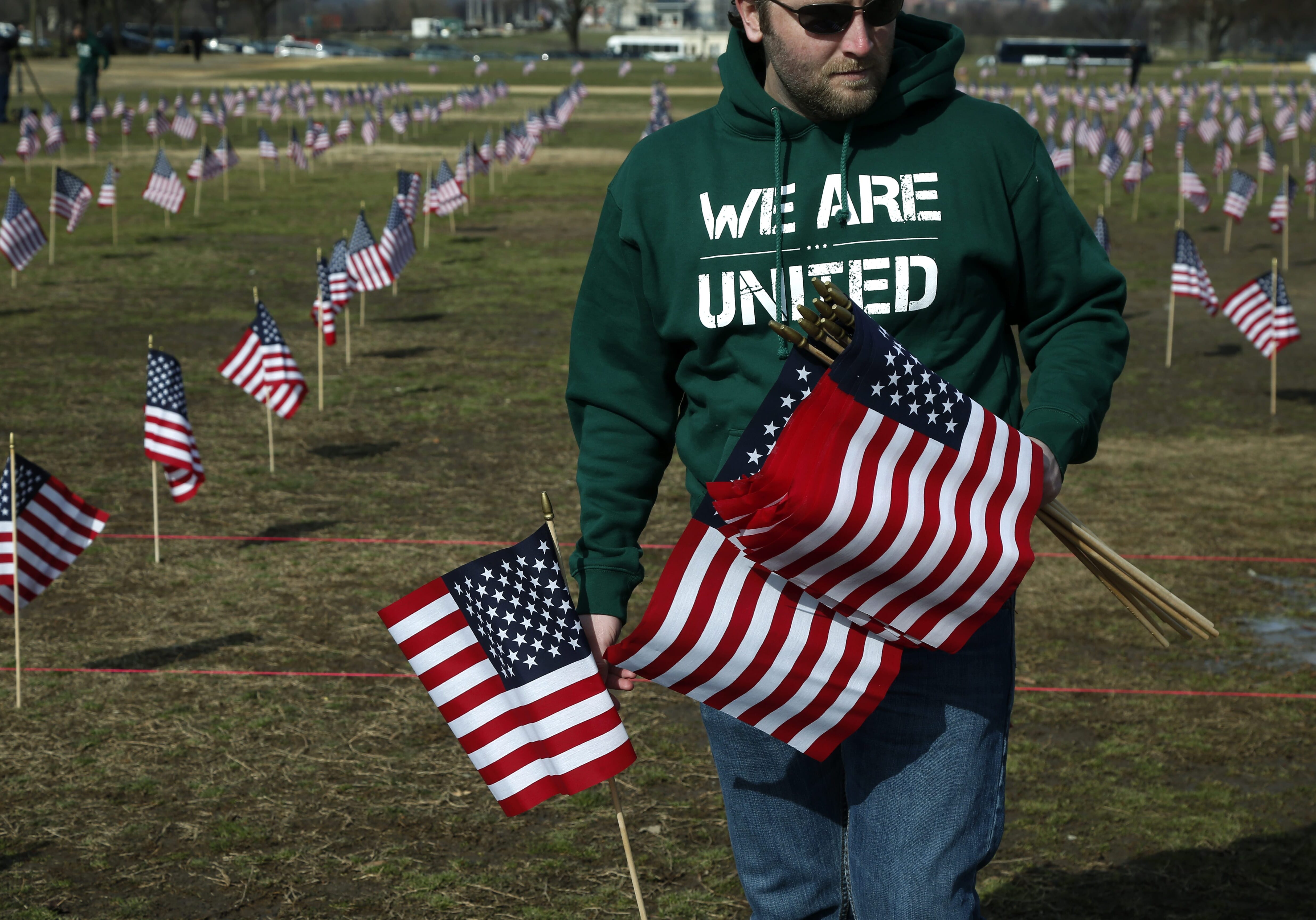 Army veteran Michael Blazer from Lebanon, Tenn., now with Iraq and Afghanistan Veterans of America (IAVA), joins others to place 1,892 flags representing veteran and service members who have died by suicide to date in 2014, Thursday, March 27, 2014, on the National Mall in Washington. The event also marked the introduction of The Suicide Prevention for America's Veterans Act by Sen. John Walsh, D-Mont., which calls for greater access to mental health care. (AP Photo/Charles Dharapak)