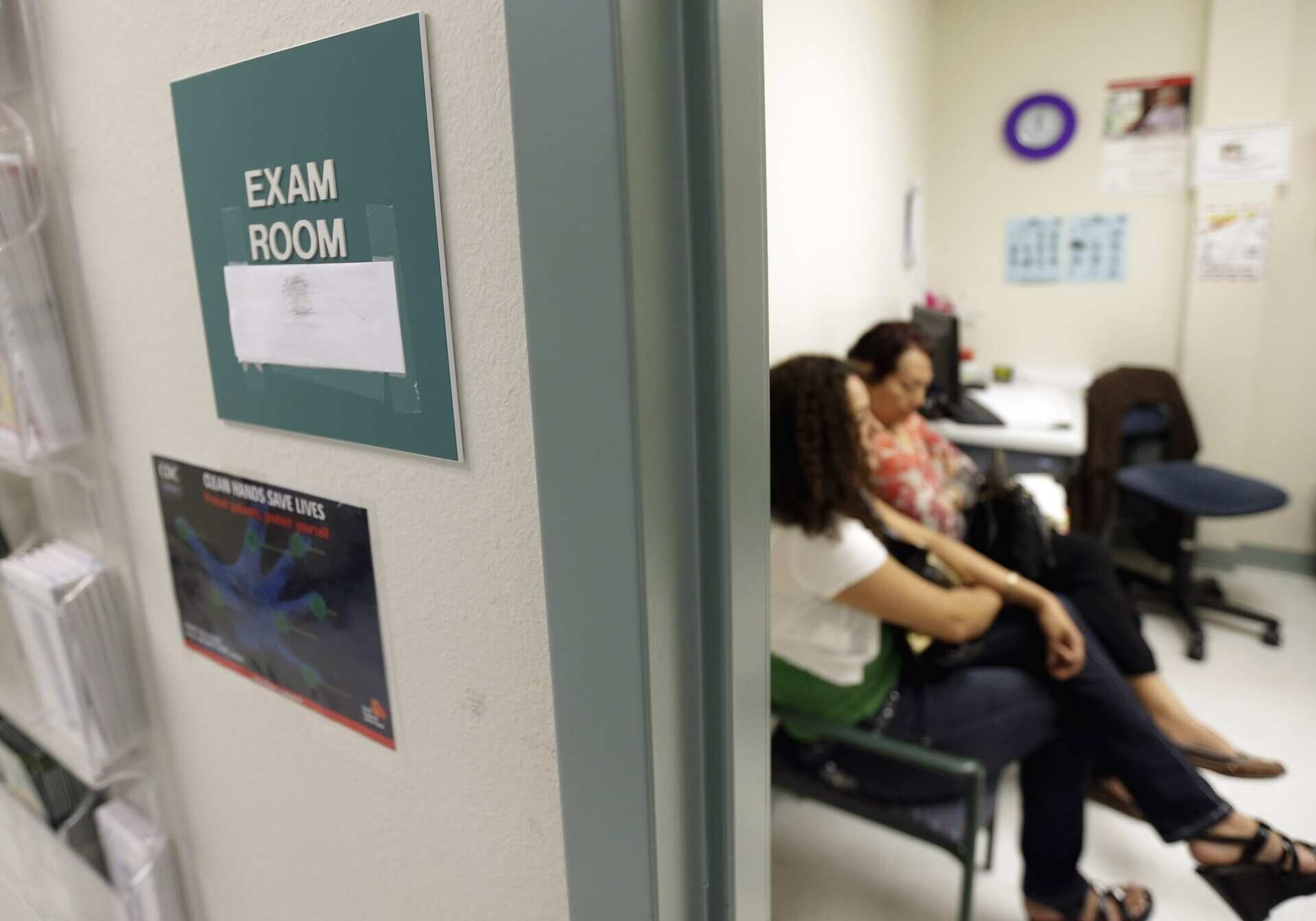 FILE - In this July 12, 2012 file photo, two women wait in an exam room at Nuestra Clinica Del Valle, in San Juan, Texas. About 85 percent of those served at the clinic are uninsured. Liberal Democratic members of Congress are warning President Barack Obama to not cut the Medicaid health care program as part of negotiations with Republicans over avoiding the so-called fiscal cliff.  (AP File Photo| Eric Gay)