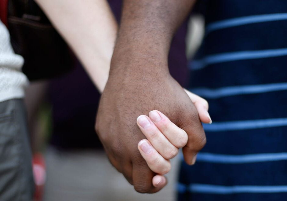 a white woman and black man hold hands