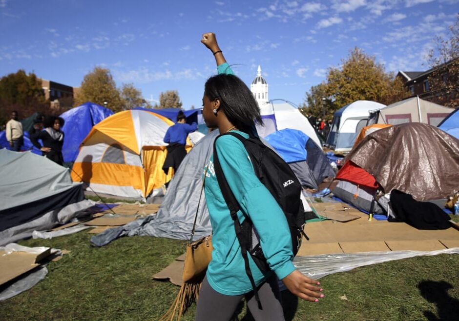 A woman passes a tent encampment set up by student protesters at the University of Missouri following an announcement that University of Missouri System President Tim Wolfe resigned Monday. (Photo: Jeff Roberson | AP)