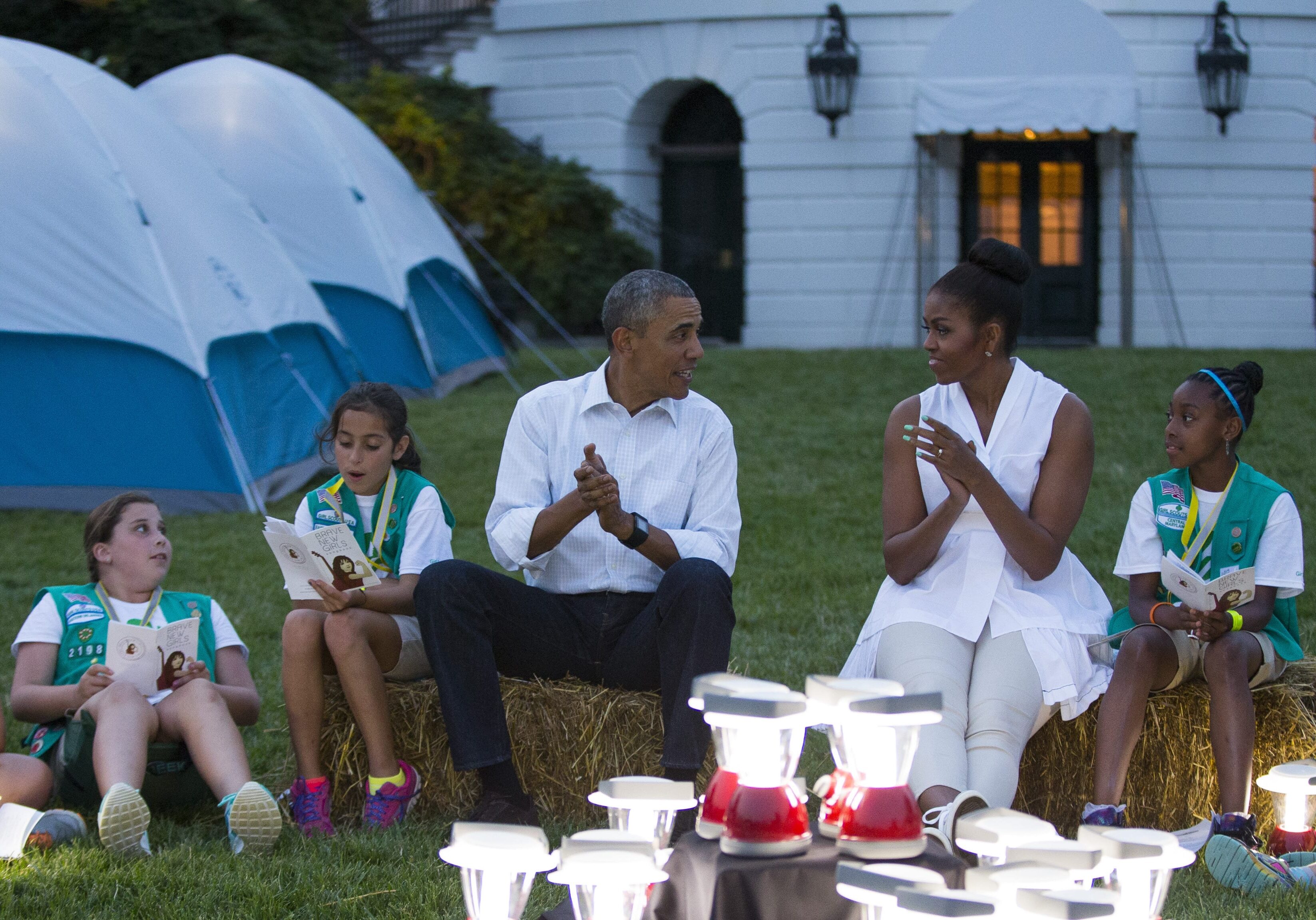 President Obama and Michelle Obama entertain during a Girl Scout campout on the South Lawn earlier this summer. The question is whether survivalist Bear Grylls is going allow the president to bring those lanterns on their trek. (Photo: Evan Vucci | AP)