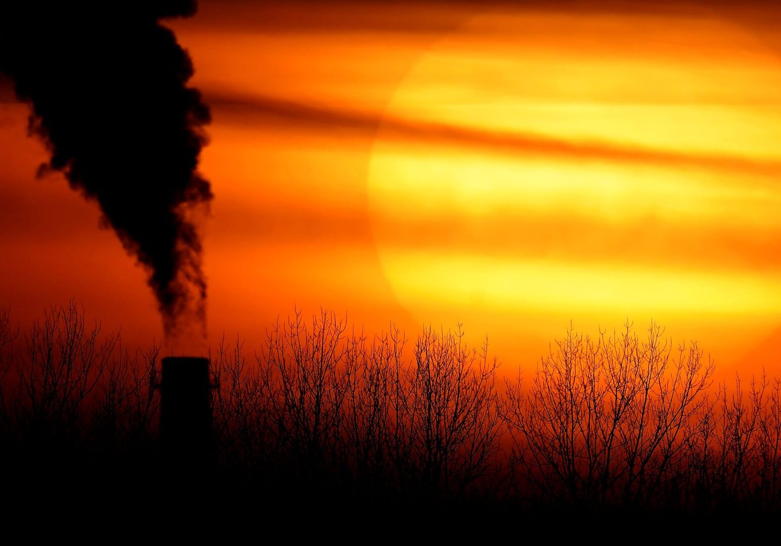 In this Feb. 1, 2021 file photo, emissions from a coal-fired power plant are silhouetted against the setting sun in Kansas City, Missouri.