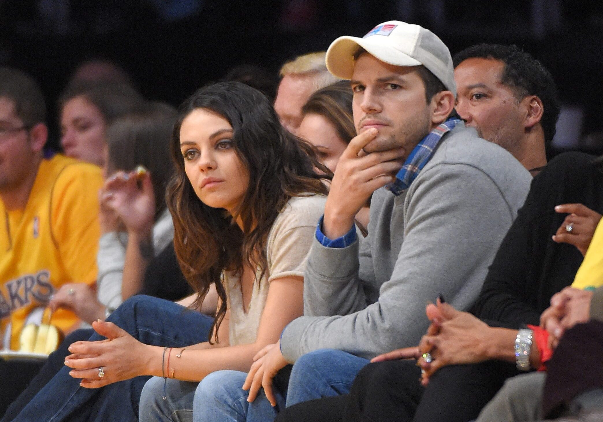 Actors Mila Kunis, left, and Ashton Kutcher watch the Los Angeles Lakers play the Oklahoma City Thunder in an NBA basketball game, Friday, Dec. 19, 2014, in Los Angeles. (AP Photo/Mark J. Terrill)