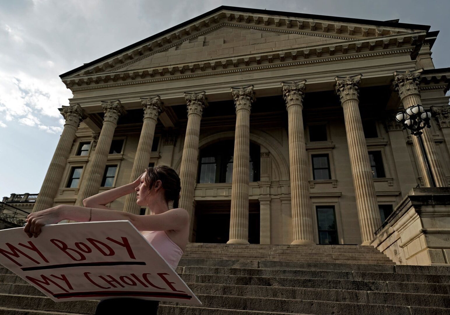 Zoe Schell, from Topeka, Kansas, stands on the steps of the Kansas Statehouse during a rally to protest the Supreme Court's ruling on abortion Friday, June 24, 2022, in Topeka.