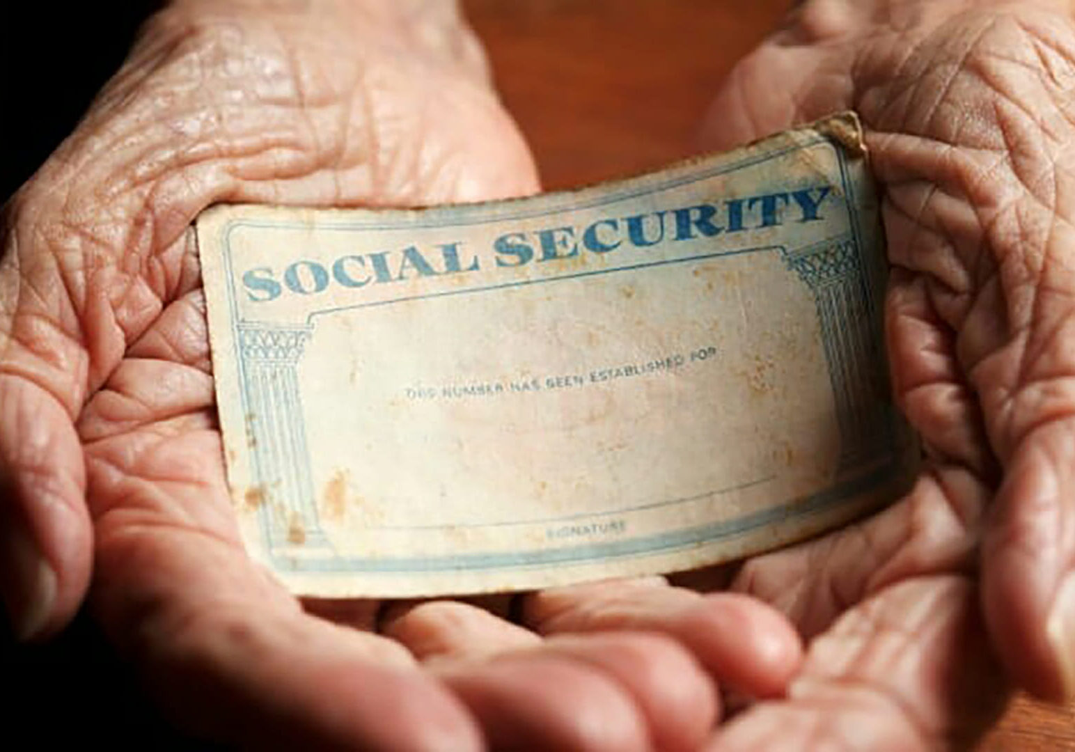 Two hands holding a Social Security card.
