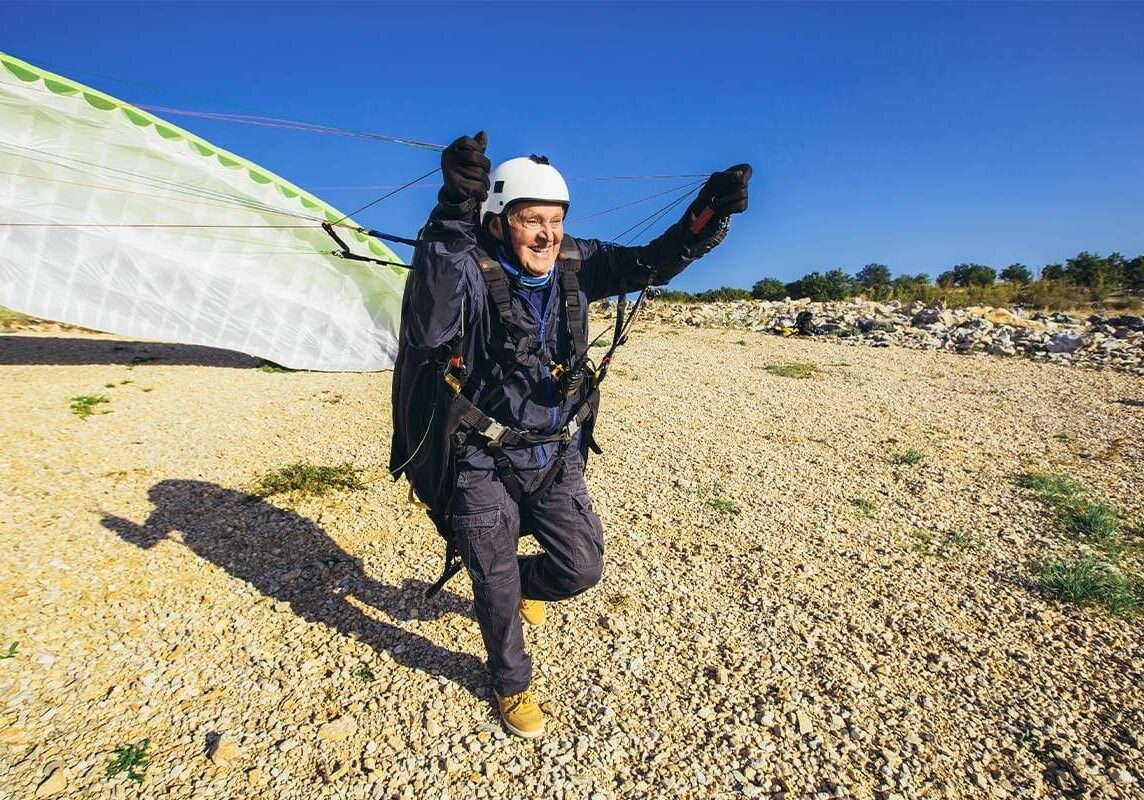 Many older adults remain active. This person is pulling a parachute to base jump.