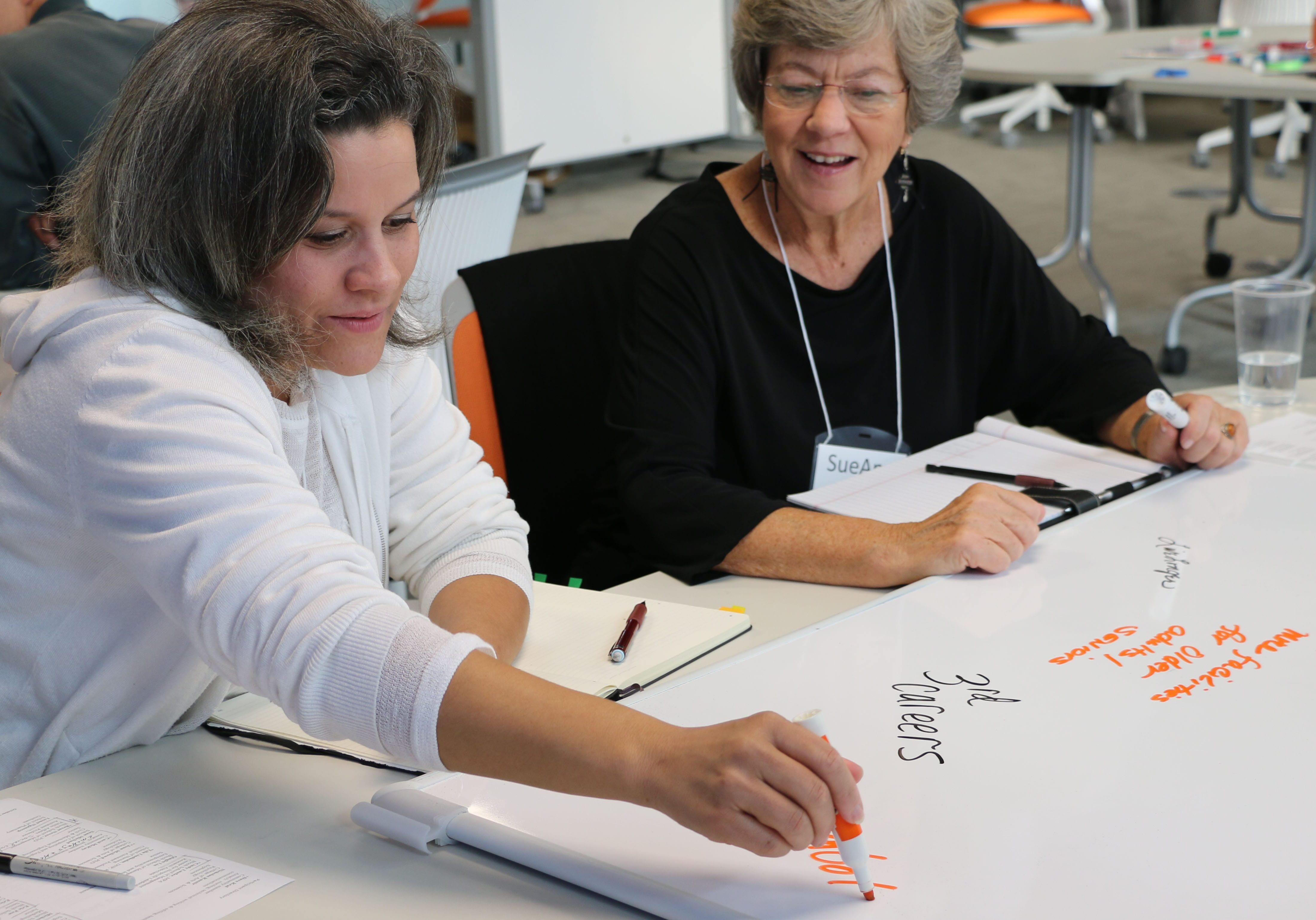 Selina ONeal and SueAnn Strom write down their ideas at the workshop for aging and innovation. 