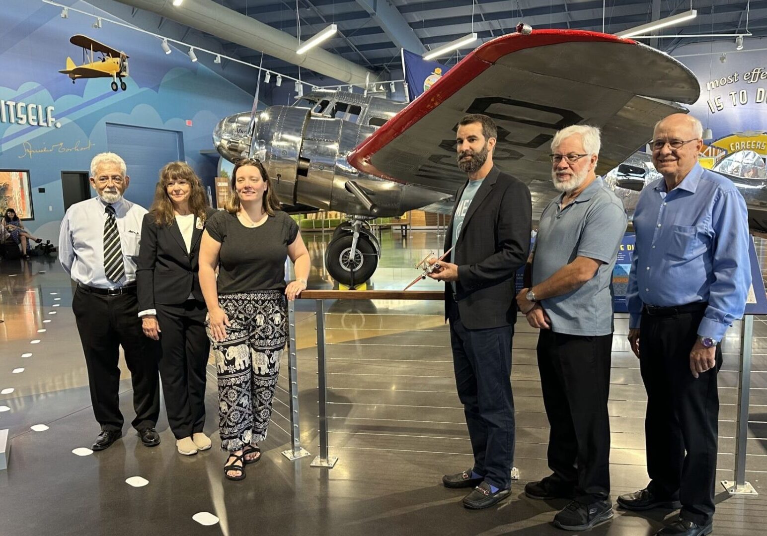 From left, Gary LaPook, Dorothy Cochrane, Liz Smith, Tony Romeo, Lloyd Romeo and Rod Blocksome stand in front of Muriel, a plane identical to the one in which Amelia Earhart and Fred Noonan took their fateful last flight.