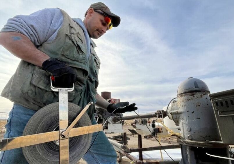 Brownie Wilson of the Kansas Geological Survey uses a metal measuring tape to determine the depth of the aquifer's water level in western Kansas. Statewide aquifer levels dropped by nearly two feet over the past year — this third-largest decline since the 1990s.