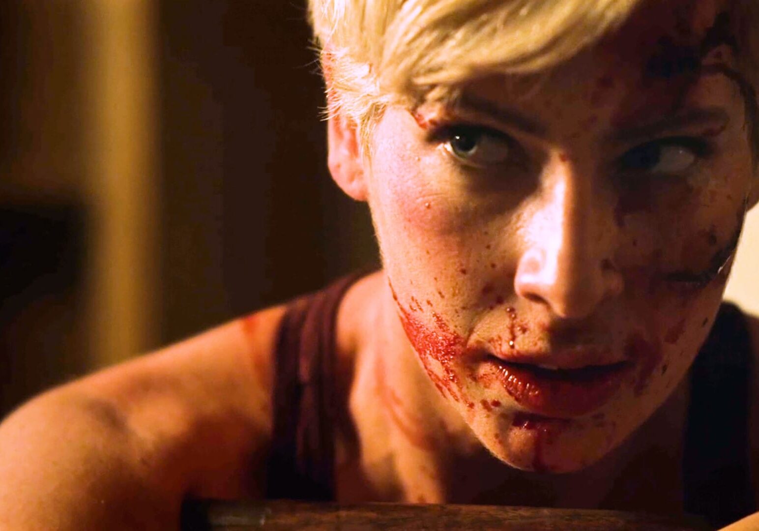 A scene from Patrick Rea's "They Wait in the Dark" shows a woman's blood-spattered face.