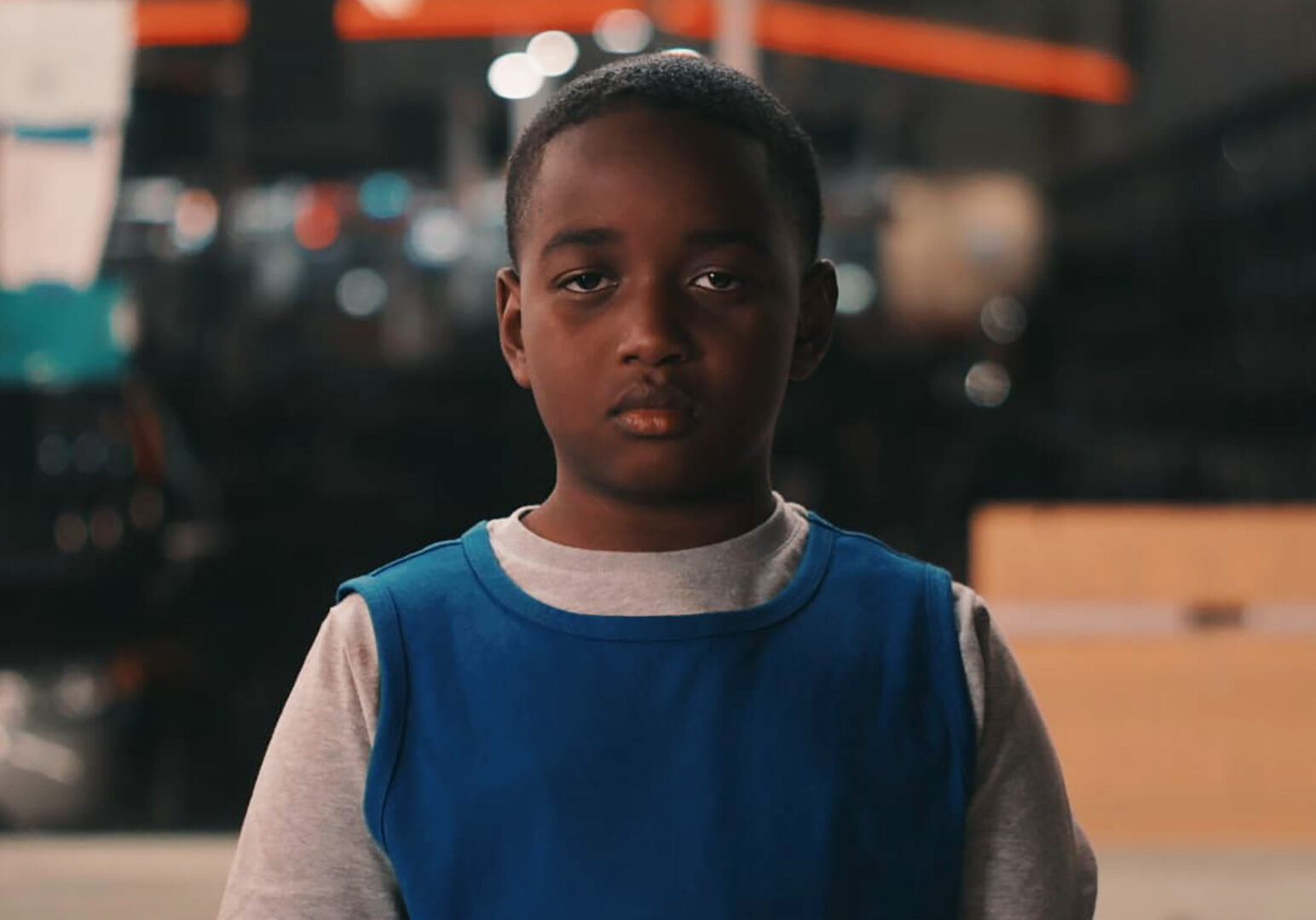 A boy in a laundromat stares at the camera in a scene for the movie "Vie."