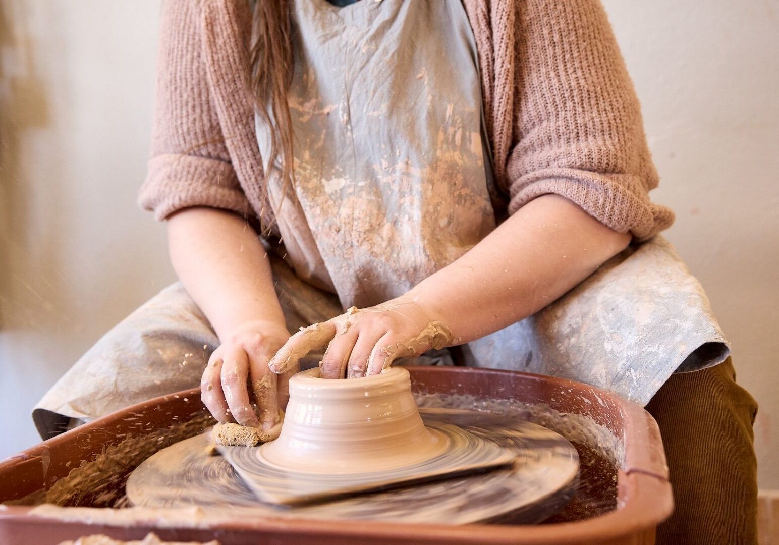 An artist working on a potters wheel at Epic Arts.