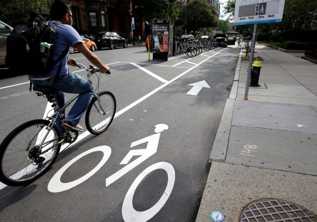 In this Tuesday, Aug. 16, 2016, photo, a cyclist enters a bike lane that is routed between parked cars and the sidewalk in Boston. Cities around the world are increasingly changing bike lanes to make them safer in light of fatal crashes involving cyclists and cars. (AP Photo/Steven Senne)

