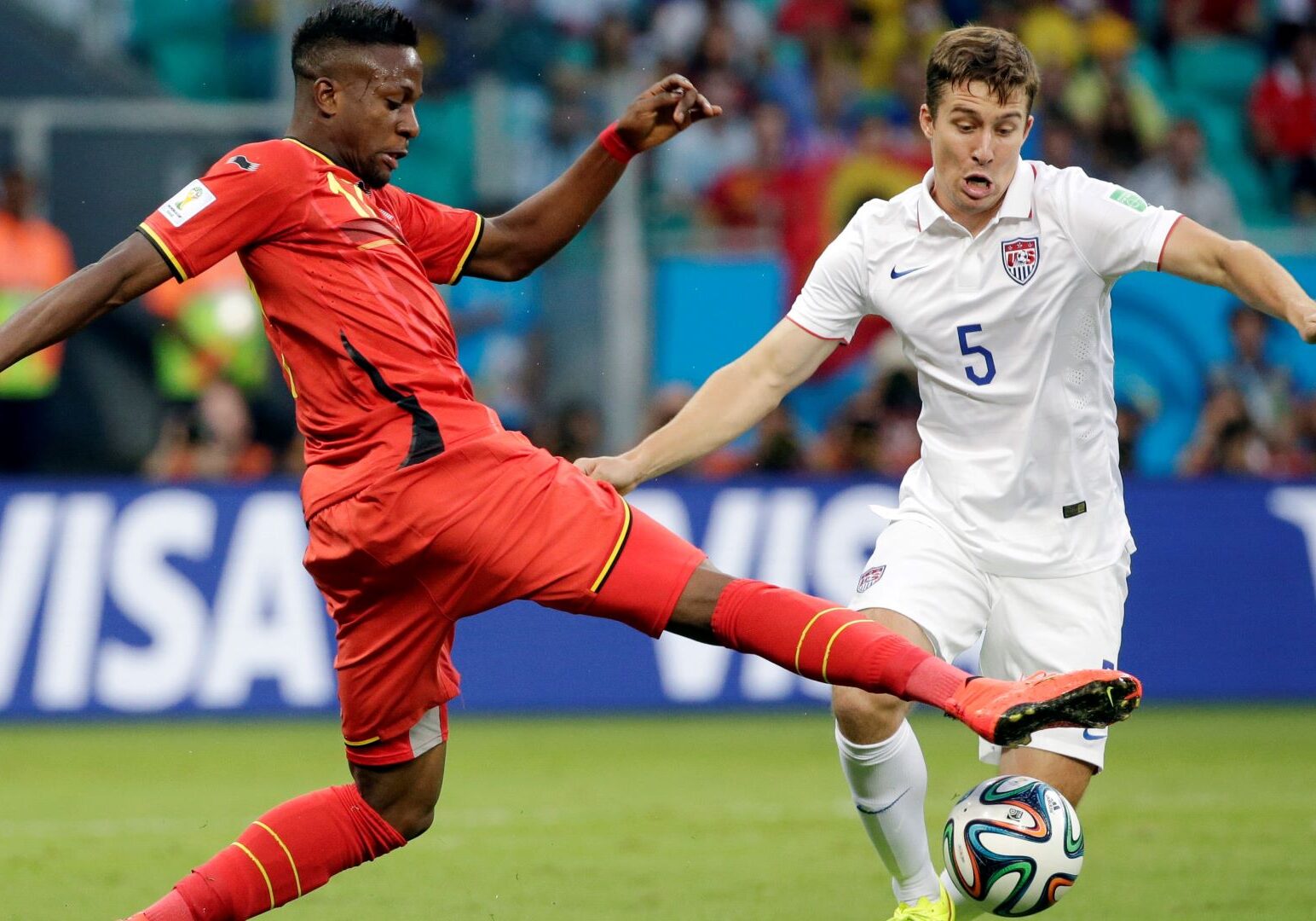 Belgium's Divock Origi, left, fights for the ball with United States' Matt Besler (5) during the World Cup round of 16 soccer match between Belgium and the USA at the Arena Fonte Nova in Salvador, Brazil, Tuesday, July 1, 2014.