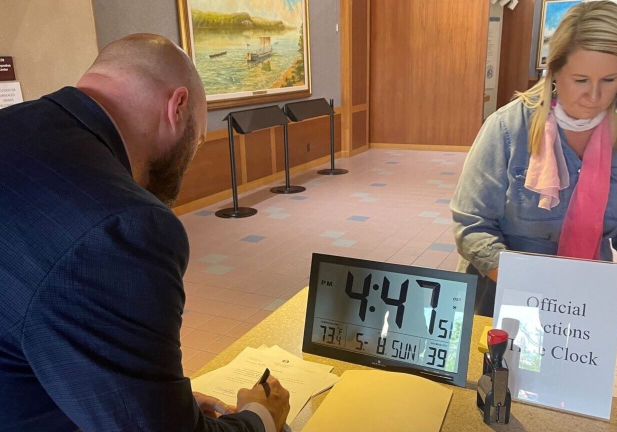 David Roland, treasurer of Better Elections Missouri, signs petition submission paperwork Sunday at the Secretary of State's office in Jefferson City.
