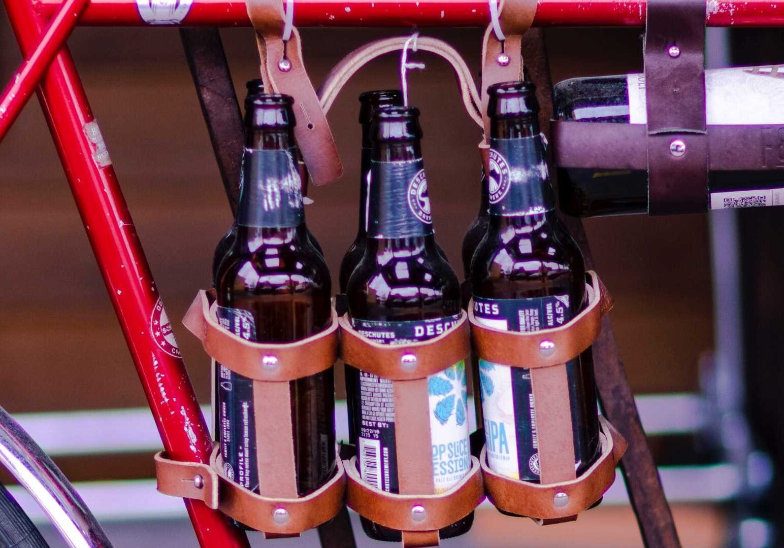 Beers dangling from a bicycle frame.