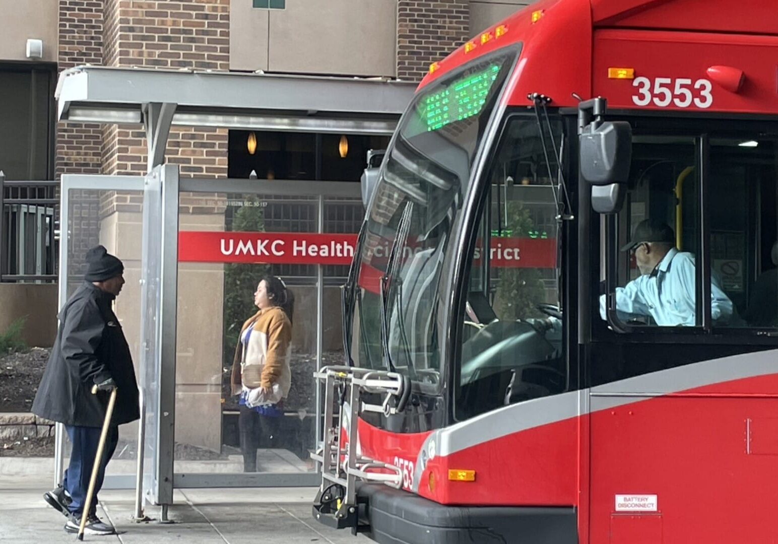 People at a bus stop at University Health.