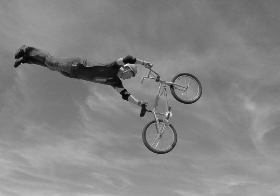 a man flies through the air doing stunts on a bike.