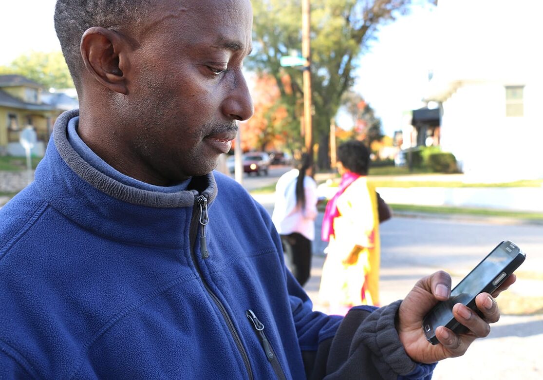 Photo of man looking at his cell phone.
