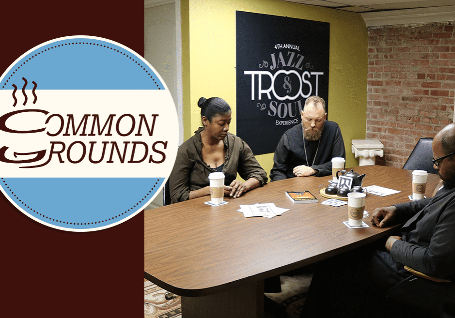 A group of people gather over coffee in prayer