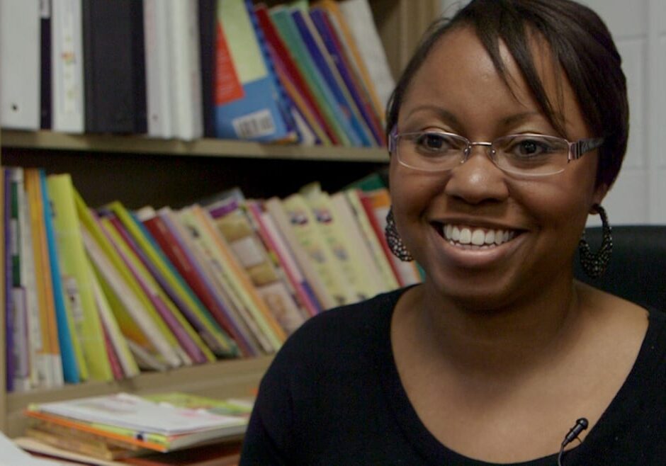 headshot of woman with books behind her.