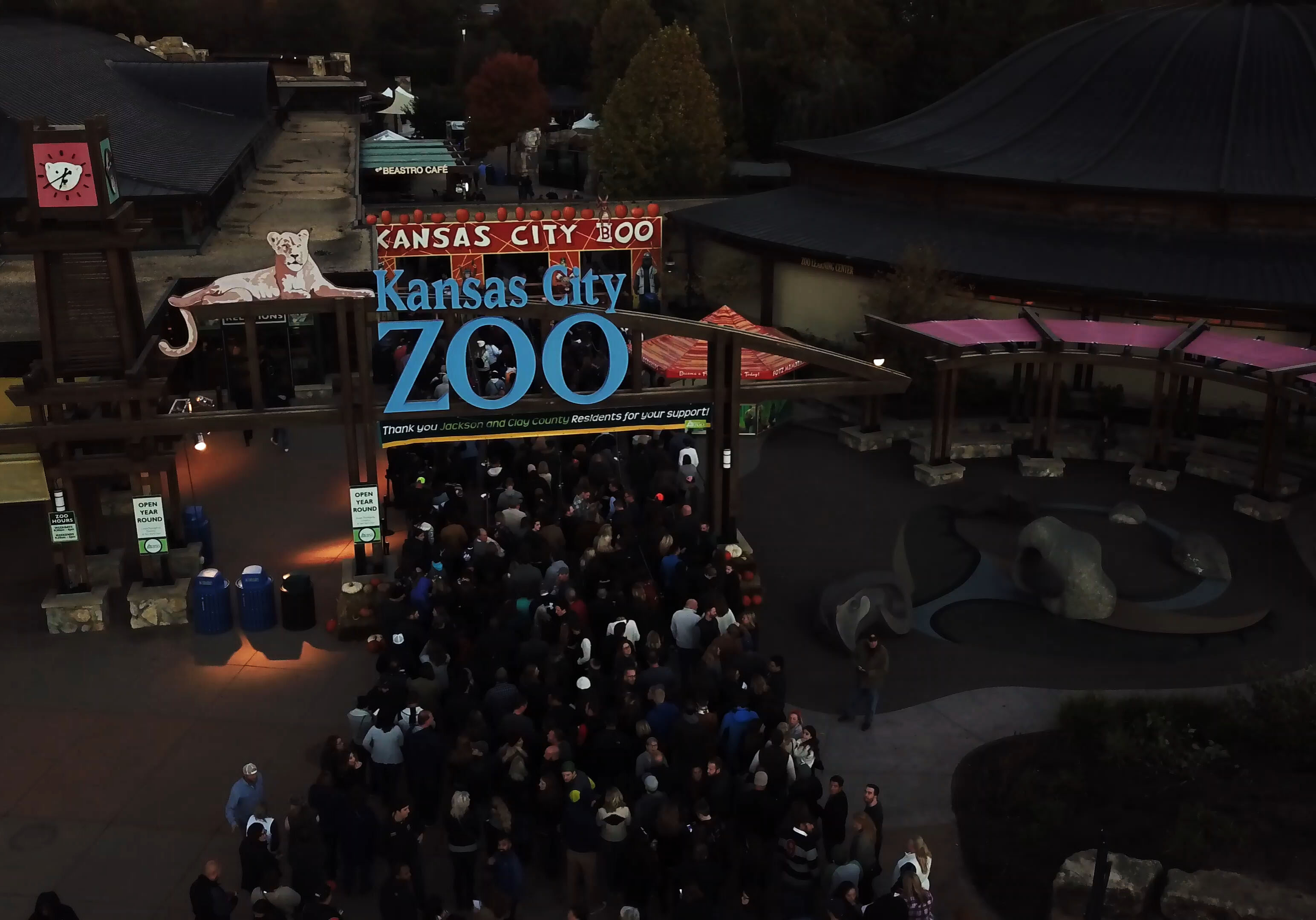 A crowd enters the zoo's front gate.