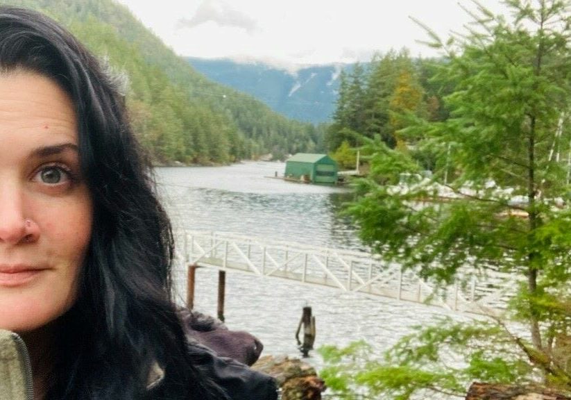 Chef Laura Comer overlooking a river in a Canadian forest.