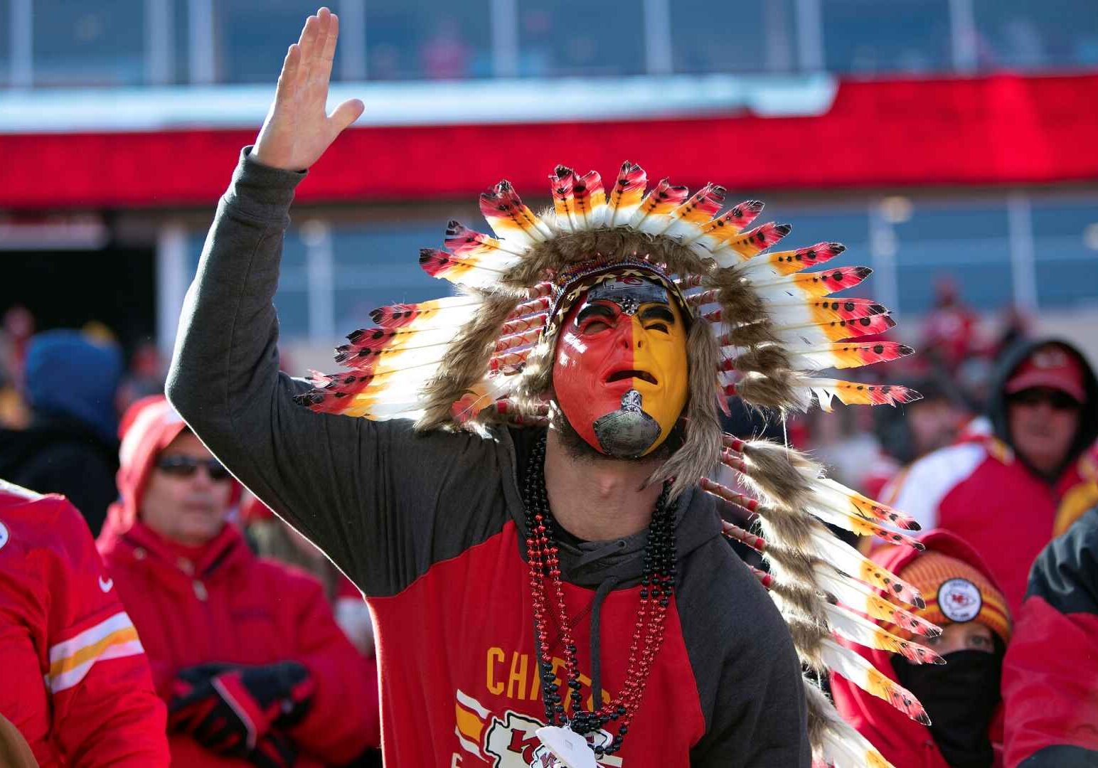 Chiefs fan in headdress doing the tomahawk chop