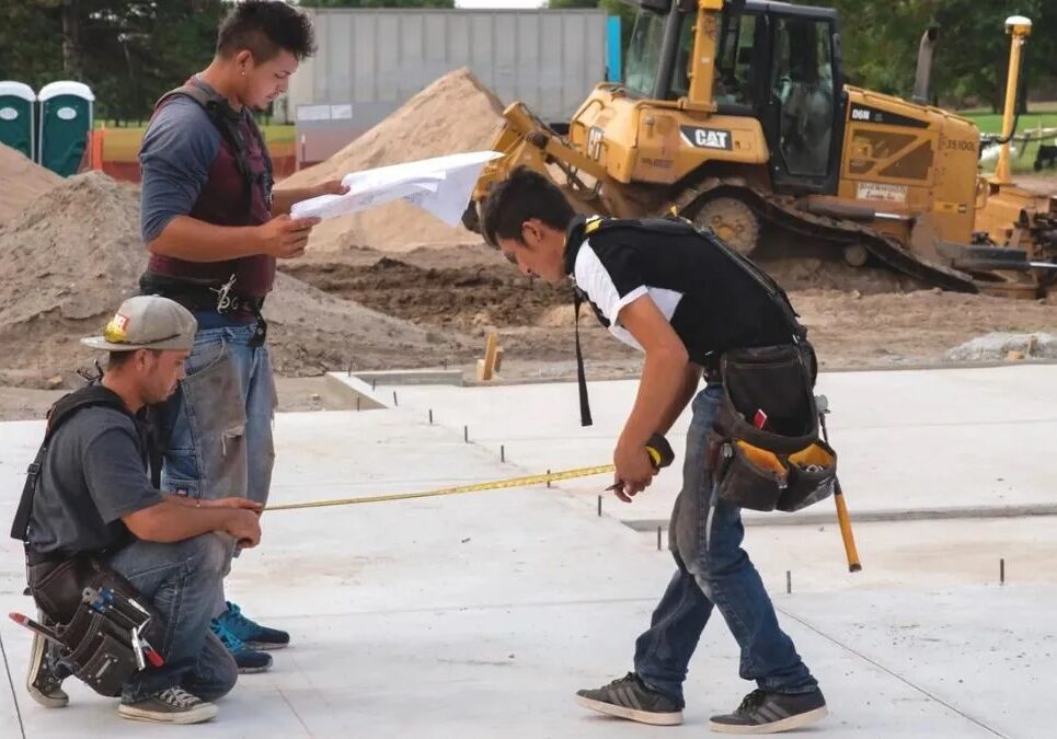 Three men working on a house construction site.