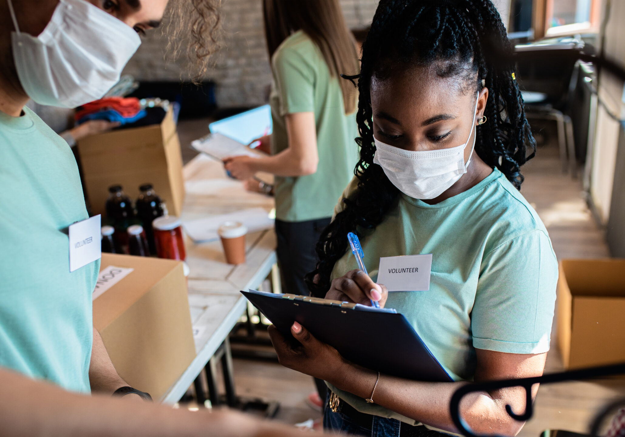 Volunteers sign a clipboard.