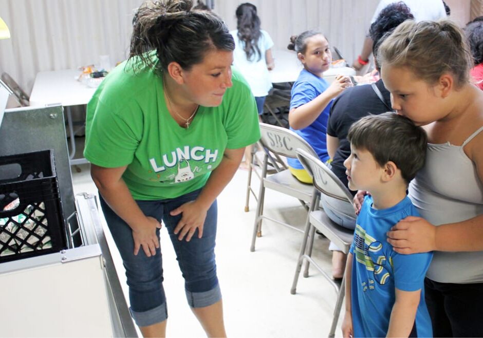 Kristen Hanks, who works in the Fort Osage school district cafeteria program, hands out lunches at Susquehanna Baptist Church in Independence, Missouri, a government-funded summer meal site. For children in the Kansas City metro area, food insecurity rises in the summer, but food sites like these are rare in rural areas. (Lindsay Huth | Flatland