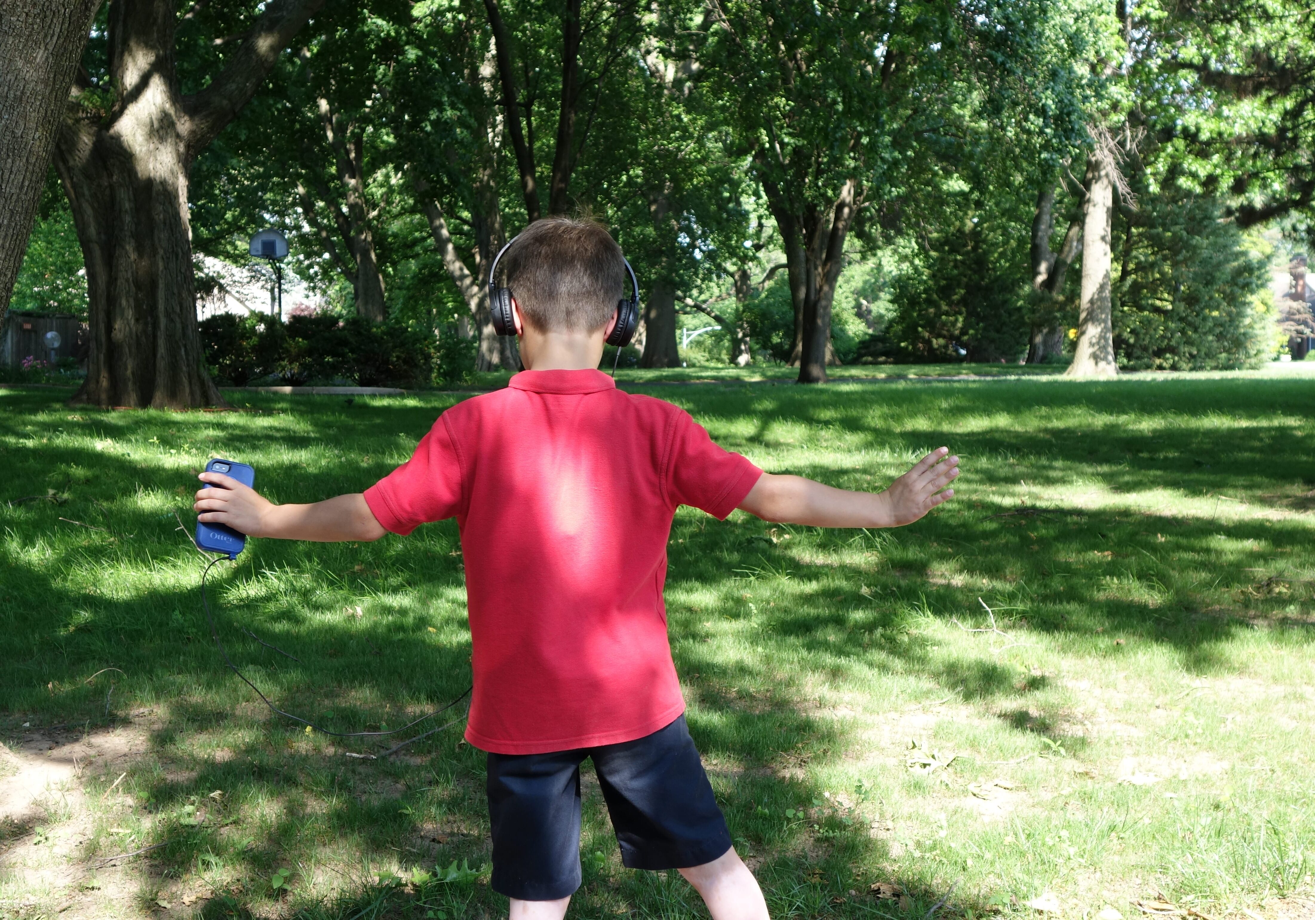 A young boy dancing with a Walkman