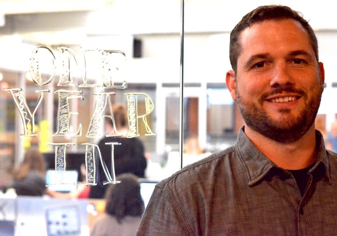 A man stands by a window.