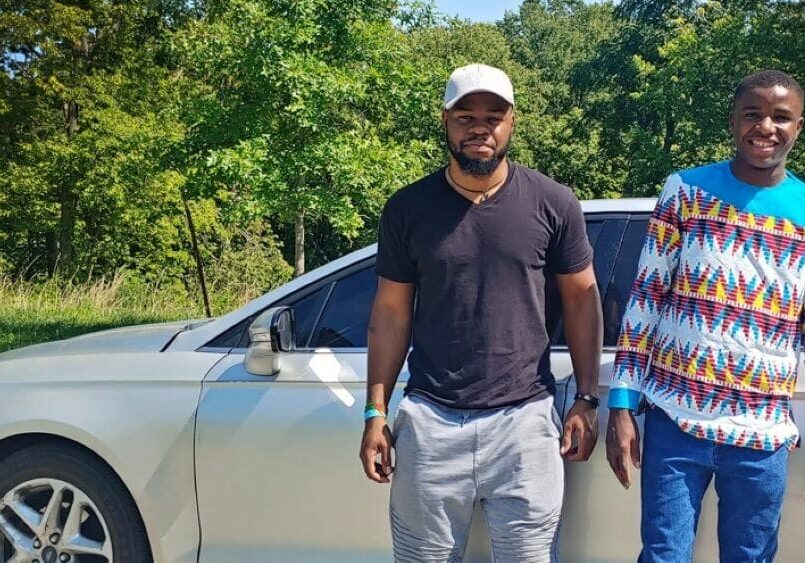 Justin Bilombele (left) and Amuri Justin (right) are stand outside of the car in Kessler Park, where Bilombele taught Justin how to drive.