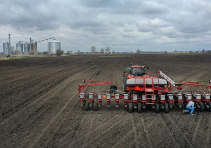 A farmer works on his planter in a field.