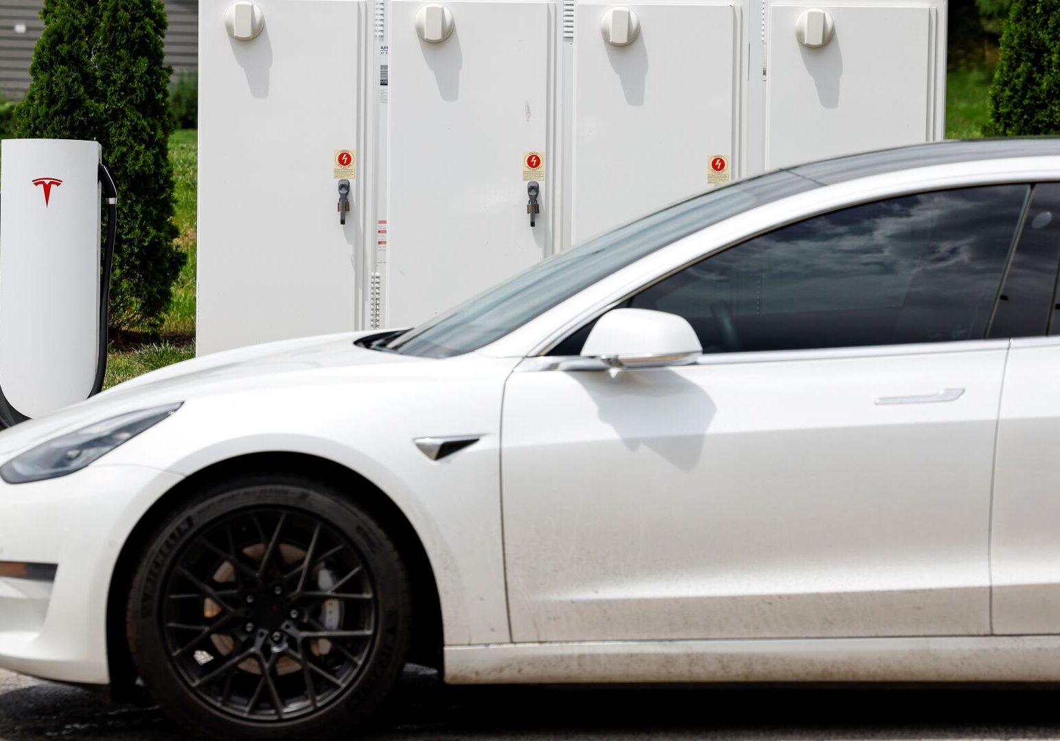 A detail view of a motorist charging their vehicle with a Tesla urban supercharger, Sunday, June 12, 2022, in Kansas City, Mo.