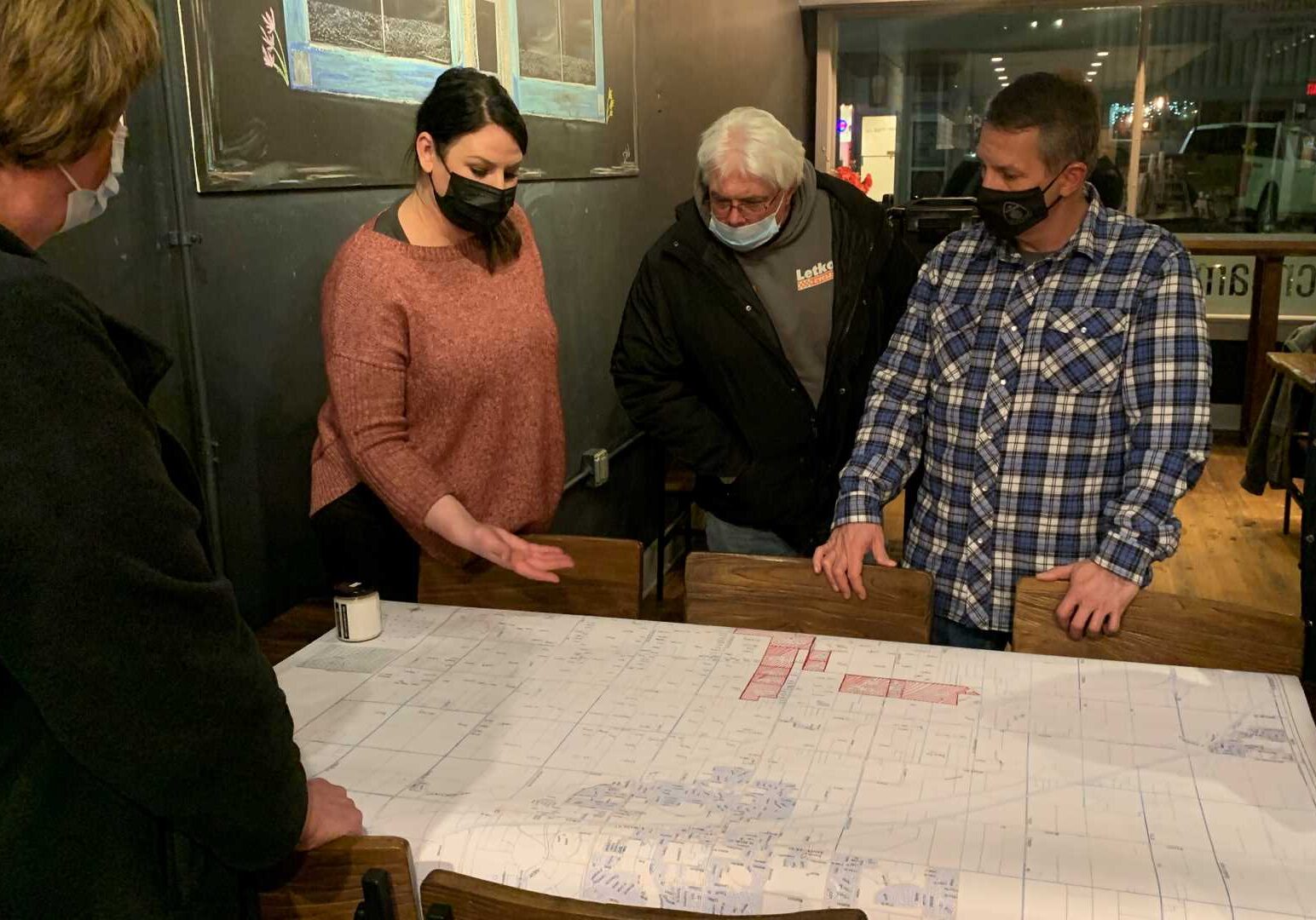 Jenni Koch shows other residents the parcels of land up for rezoning at The Coffee Bean Co. in Spring Hill, Kansas, on Feb. 9, 2021.