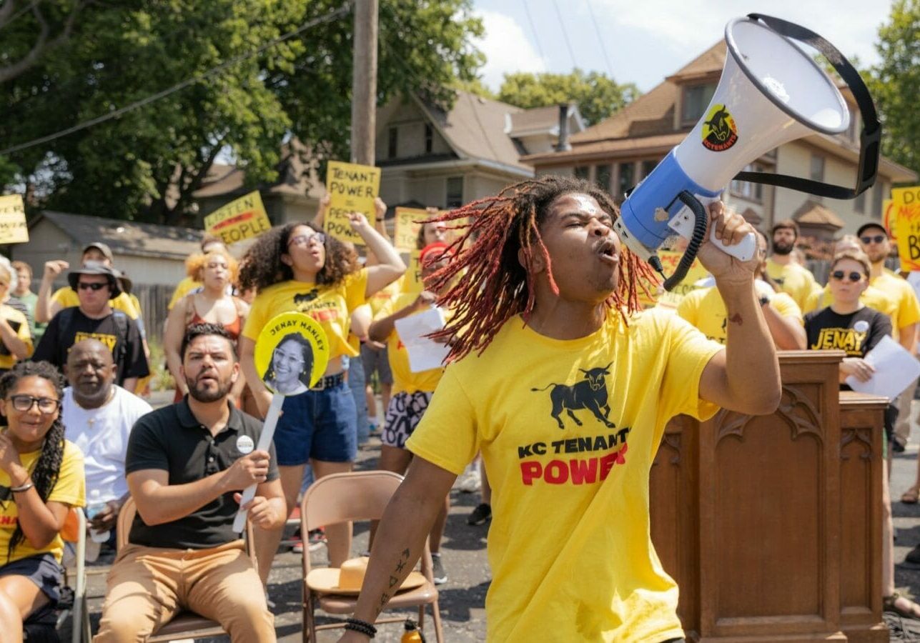 A participant in a KC Tenants Power political rally uses a megaphone to fire up the crowd.