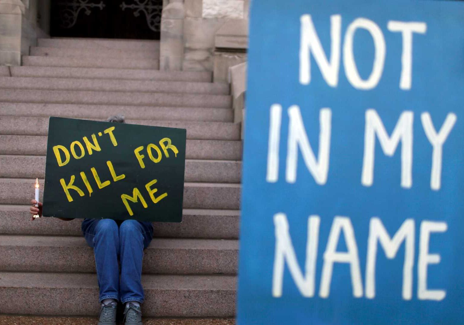 Death penalty opponents Joyce Engle, left, and Kate McCoy hold a signs as they take part in a vigil outside St. Francis Xavier College Church ahead of the scheduled execution of Missouri death row inmate Russell Bucklew on Tuesday, May 20, 2014, in St. Louis.