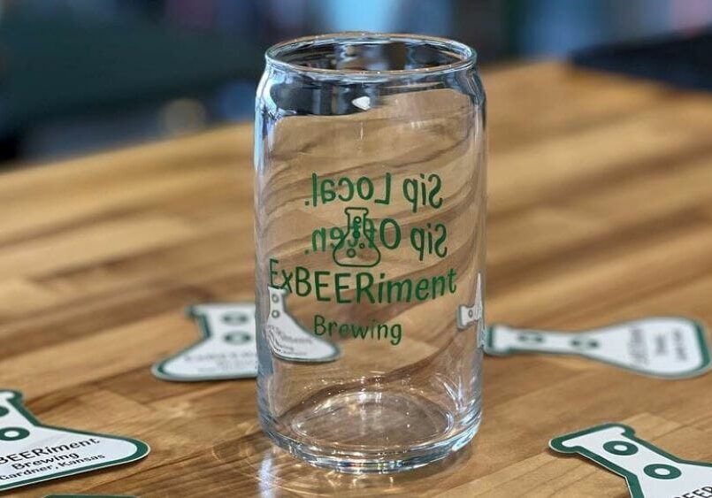 An ExBEERiment glass on a bar.