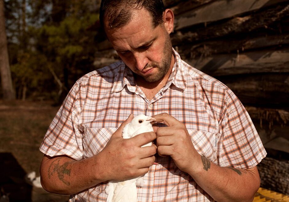 U.S. Army veteran Alex Sutton cradles a rock dove show pigeon